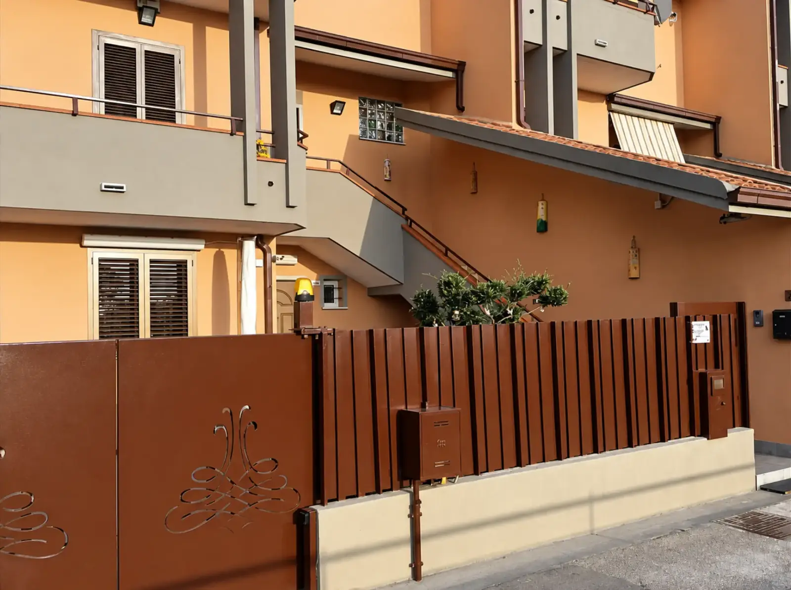 Facciata del B&B La Villetta con le pareti color terracotta e il cancello marrone a Macerata Campania